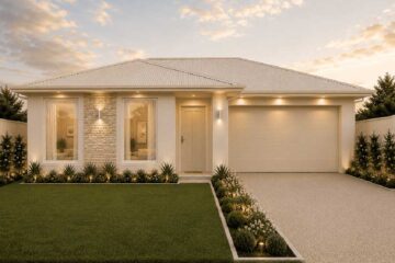 Modern single‑story home with stone facade, manicured lawn, and warm entry lights at dusk.