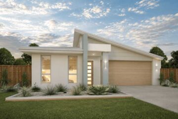 Modern single-story house with a two-car garage, manicured lawn, and desert landscaping.